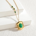 Collar dorado minimalista con colgante hexagonal y piedras verdes en fondo blanco - Collar
