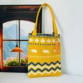 Detail of knitted tote bag with polar bear patterns and geometric blue wave textures - Little Bear Yellow