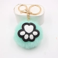 Detail of mint green plush ball keychain with black cat paw print and gold metal clasp - Cat Claw Gold Keychain / Mint Green