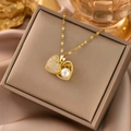 Detailed close-up of a 18k gold heart-shaped pendant with white pearls and zircons - Gold Pearl Heart
