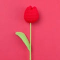 Detailed view of a handmade red crochet tulip with green stem on a red background - Red - Large Single Stem