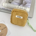 Detail of ginger corduroy makeup bag featuring a zip closure and woven brand label - Turmeric