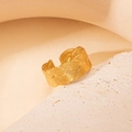 Wide gold adjustable ring with leaf texture on minimalist stone display stand - Wide Woven - Gold