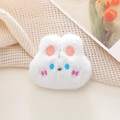 Close-up of a soft white plush bunny brooch with detailed pink and blue embroidery - White Rabbit