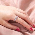 Details des silbernen Eternity-Rings mit Zirkonia-Steinen auf rosa Seidenhintergrund - Silber Ewigkeitsring
