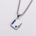 Macro shot of silver book locket pendant with blue spine and heart cutout details - Blue