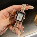 Détail d'une montre bracelet en perles or rose avec lunette en cristal brillant - Or rose