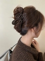 Dettaglio di una grande pinza per capelli marrone opaco su un'acconciatura a chignon - Caffè Scuro