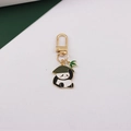 Detail of panda keychain with gold plating, black and white enamel, and bamboo charm - Panda with Bamboo Hat - Green
