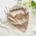 Close-up of floral headscarf with elastic band detail and pastoral pattern - Orange Floral