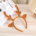 Detailed view of plush brown reindeer antlers headband on a rustic wooden desk - Coffee Antler