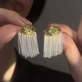 Detail of trendy metallic tassel earrings featuring gold hammered discs and silver chains - Hammered Tassel / Gold