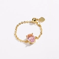 Detail of adjustable gold ring featuring a pink oval zircon stone and a heart charm - Pink Zirconia - Gold