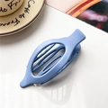 Detail view of a large blue matte oval hair claw clip on a white textured background - Matte Denim Blue