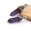 Sechseckiger Amethyst-Kristallanhänger mit silberner Metallöse auf rustikalem Holzhintergrund - Nur Anhänger / Transparentes Dunkelviolett