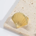Detailed view of vintage gold seashell ring with textured sunburst pattern on stone background - Shell Style / Gold