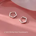 Hohlblüten Creolen aus Sterlingsilber mit elegantem Wellendesign auf rosa Hintergrund - Silber