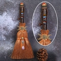 Close-up of witch broom with triple moon symbol, colorful stones and purple crystal - Unakite