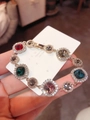 Macro detail of 925 silver bracelet featuring colorful faceted stones with pavé diamond halo - Colorful