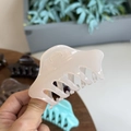 Pince à cheveux rose translucide en acrylique avec design de quille pointue tenue à la main - Blanc Gelée