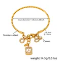 Detail view of twisted stainless steel bangle with figure 8 and zircon charms - Gold 5A Zirconia Bangle