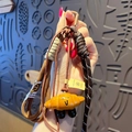 Cute yellow croissant keychain featuring a smiley face and coffee braided cord strap - Pretzel-Smiling Croissant