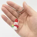 Detailed close-up of a 2.5cm mini snowman keychain with Santa hat and green gift box - Christmas Snowman Style