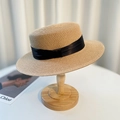 Flat top straw hat with black ribbon decoration displayed on a natural wooden stand - Khaki Black Ribbon
