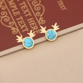 Detailed view of turquoise antler earrings in gold finish on a beige leather display - Earrings