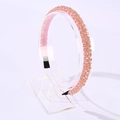Pink handmade crystal beaded headband with gold accents on a transparent acrylic stand - Pink + Gold