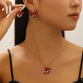 Detailansicht der herzförmigen Diamantohrringe und Football-Kette mit roten Schleifen - Schmuckset mit Roter Schleife Stil 1
