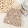 Close-up of beige knitted beanie with faux fur pom-pom, pearls and metallic beads - One Size / Off White