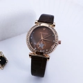 Detailed macro view of a rose gold quartz watch with rhinestones and star pattern - Coffee