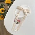Beige dubbellaagse haarstrik op een wit bord met zonnebloemen op de achtergrond - Beige