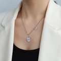 Collana con ciondolo a lettera M in acciaio inossidabile argento su una modella elegante - Color Acciaio