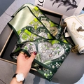 Green and white floral silk scarf with heart pattern held to show texture and drape - Heart Sakura