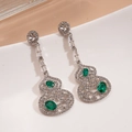 Élégantes boucles d'oreilles gourde argentées avec pierres vertes sur assiette blanche - Argent (Tige de boucle d'oreille en argent sterling 925)