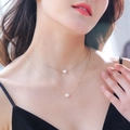 Double-layered gold necklace with two round white pearls worn by a model on plain background - NZ380-Gold Double Layer Natural Pearl