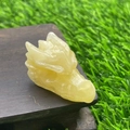 Detailed view of a 4cm translucent yellow natural stone dragon head on a wooden stand - Golden Steatite