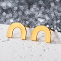 Macro shot of matte gold U-shaped geometric earrings on a white stone base - U Shape / Gold