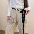 Detail of polka dot silk scarf belt with pearl accents styled on a white top and beige pants - Black and White Polka Dot Pearl Lace-up Waist Chain