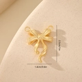 Macro shot showing dimensions of a golden zircon bow pendant for jewelry making - Brushed Metal Style MYYX00630 / Gold
