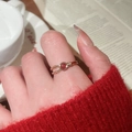 Detail of a gold bamboo-style ring with red stone and zircon worn by a model - Round Red Stone Ring (Gold Plated)