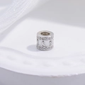 Makroaufnahme einer Silber-Zylinderperle mit Zirkonia und Mantra-Gravur für DIY - 5mm Groß / Weißgold