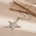 Close-up of vintage starfish pendant with spiral texture and matte silver finish - Vintage Silver Starfish