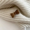 Close-up of dark brown velvet bow hair clip on a white knit sweater texture - Brown
