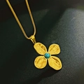 Primer plano de collar de flor dorada con incrustación de turquesa sobre fondo negro - Collar de Turquesa