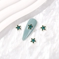 Pentagram star nail charm with emerald green gems and gold alloy base on blue fake nail - Gold Peacock Green Zirconia