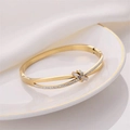 Elegant rose gold knot bangle with sparkling rhinestones on polished stainless steel - Gold