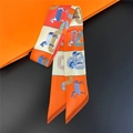 Detalle de pañuelo twilly de seda con motivos de caballos y líneas en empaque naranja - 90cm / Naranja Marino Ecuestre